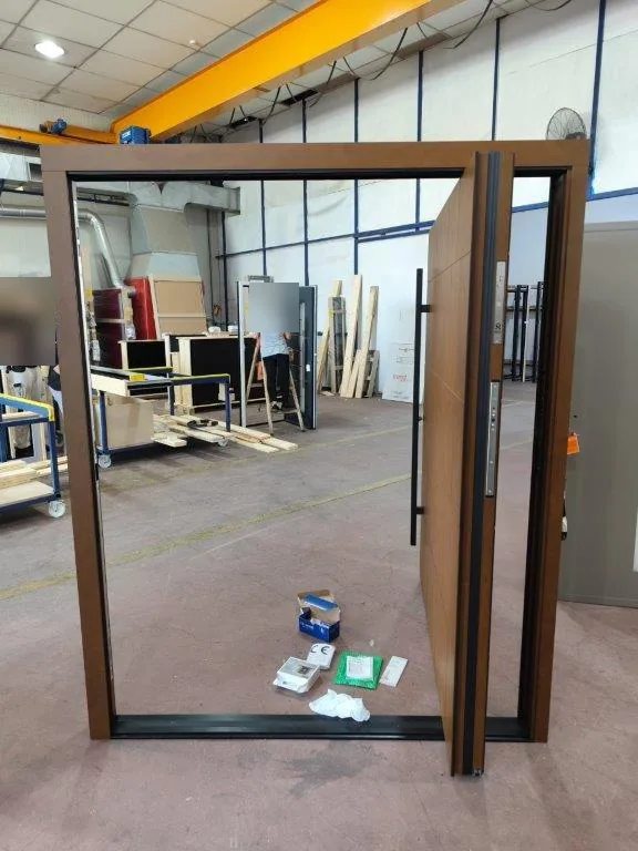 Porte pivot aspect corten ouverte : le pivot désaxé laisse un large passage
