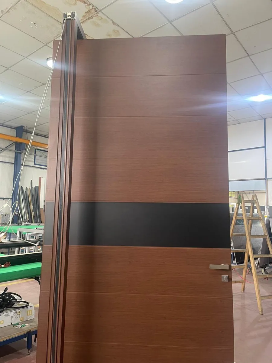 Face intérieure de la porte pivot décor bois : poignée inox et axe pivot