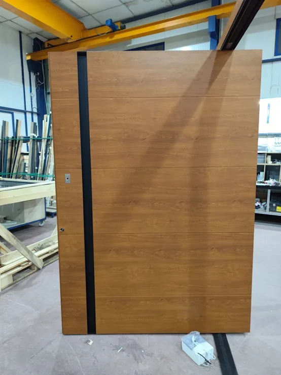 Porte d’entrée pivot décor chêne doré avec barre de tirage noire encastrée